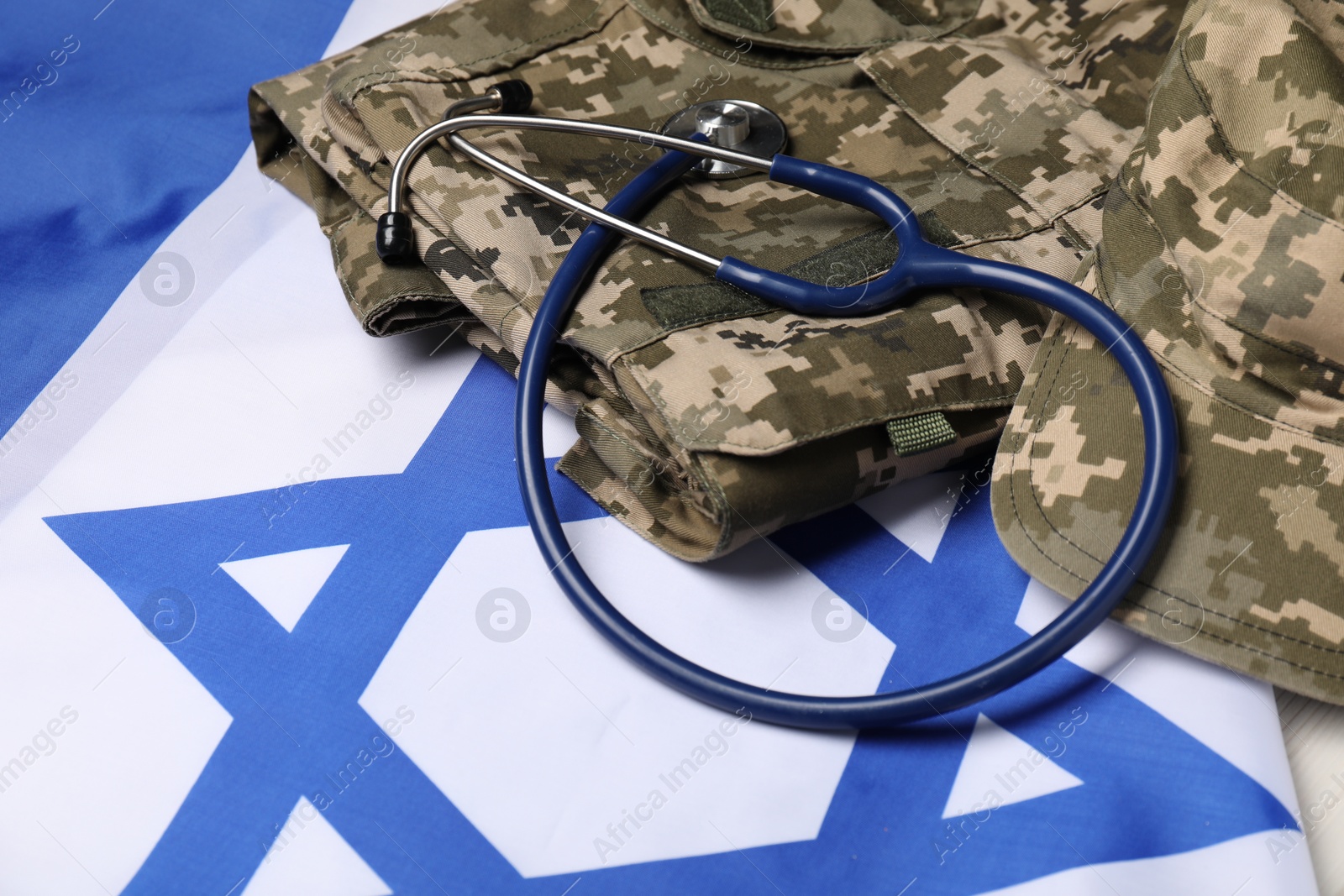 Photo of Stethoscope and military uniform on flag of Israel, closeup