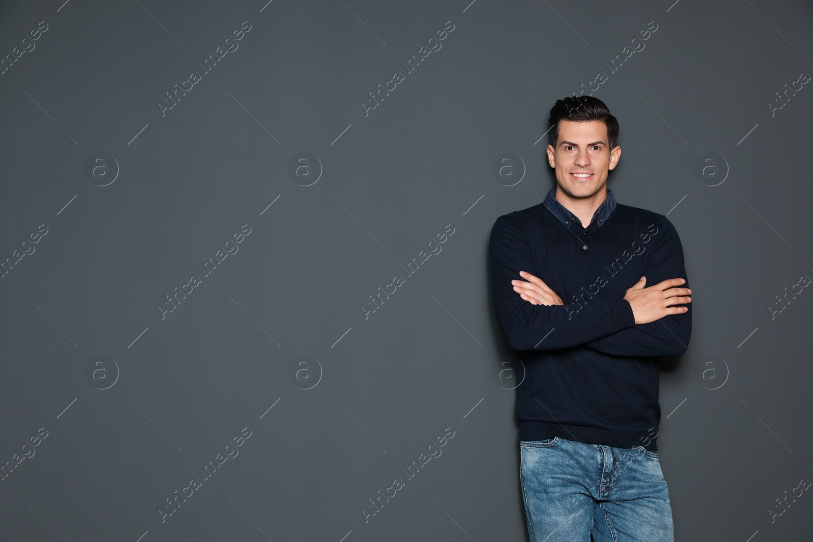 Photo of Portrait of handsome man smiling on grey background. Space for text