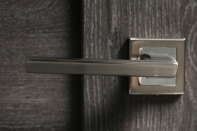 Photo of Wooden door with metal handle, closeup view