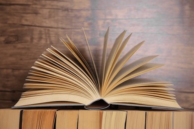 Photo of Different books against wooden background, closeup view