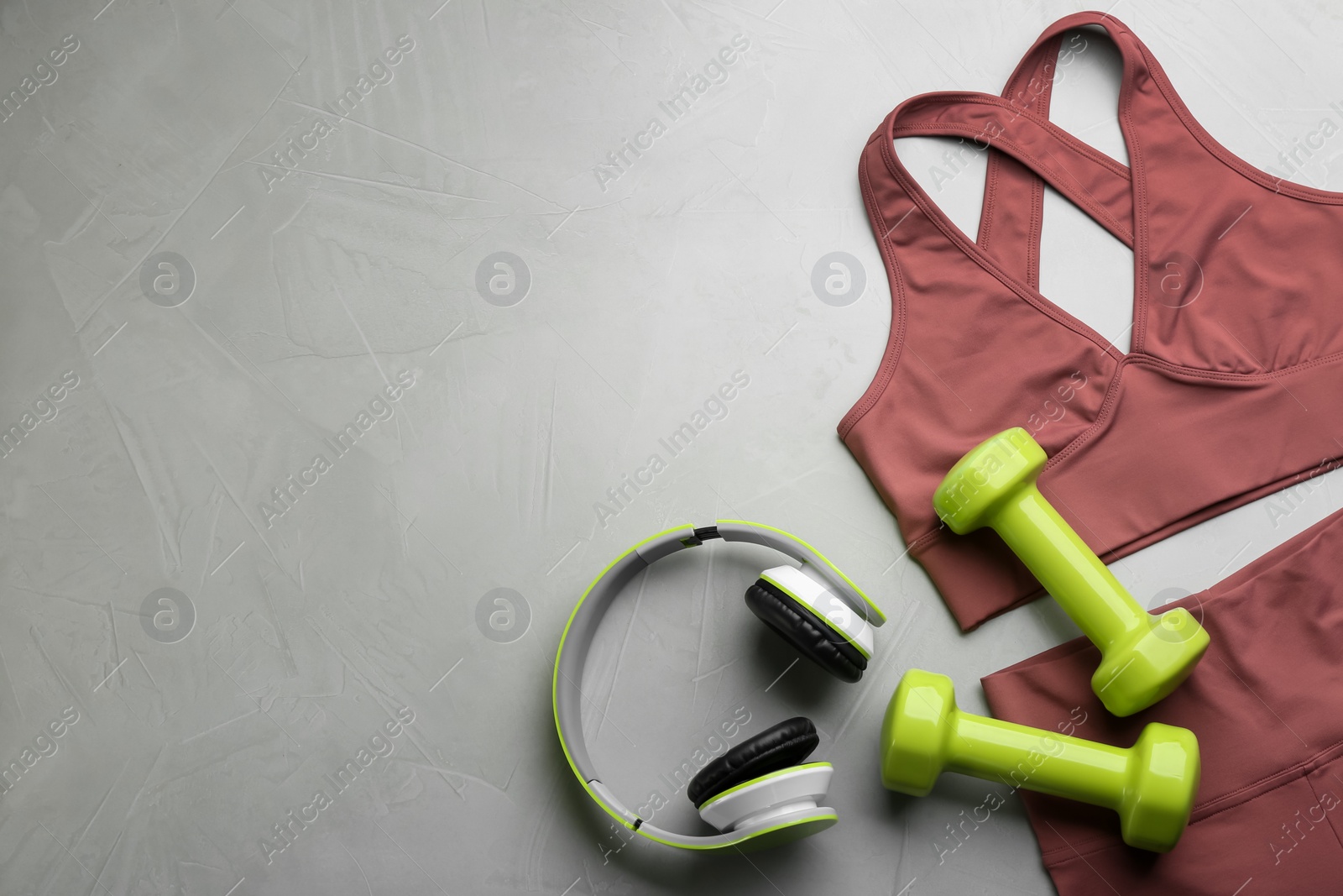 Photo of Flat lay composition with sportswear and equipment on light grey table, space for text. Gym workout