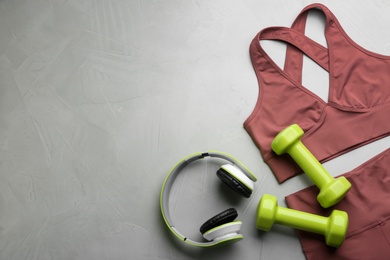 Flat lay composition with sportswear and equipment on light grey table, space for text. Gym workout