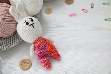 Photo of Crocheted bunny and threads on white wooden table. Engaging in hobby