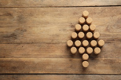 Photo of Christmas tree made of wine corks on wooden table, top view. Space for text