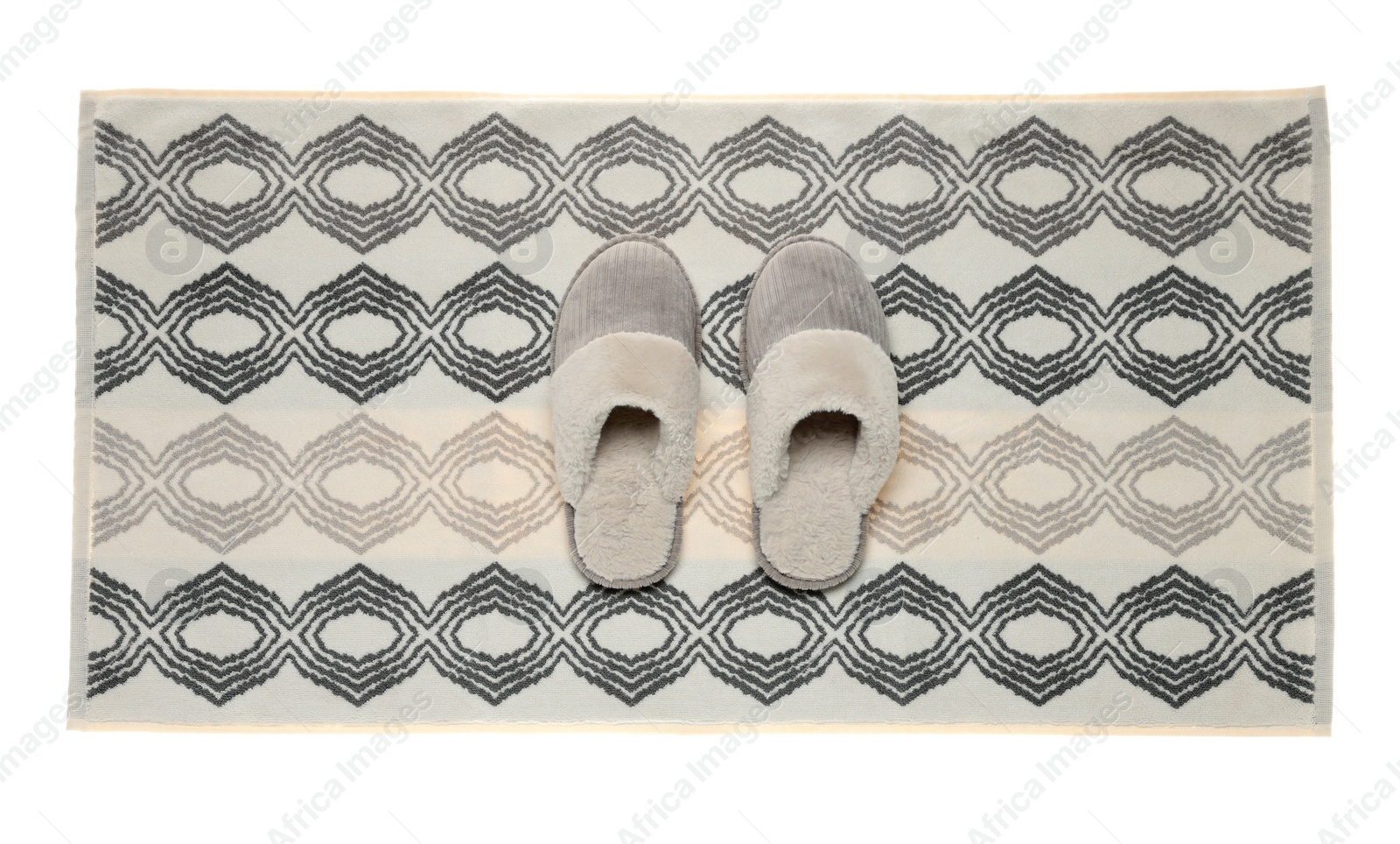 Photo of Soft bath mat and slippers isolated on white, top view