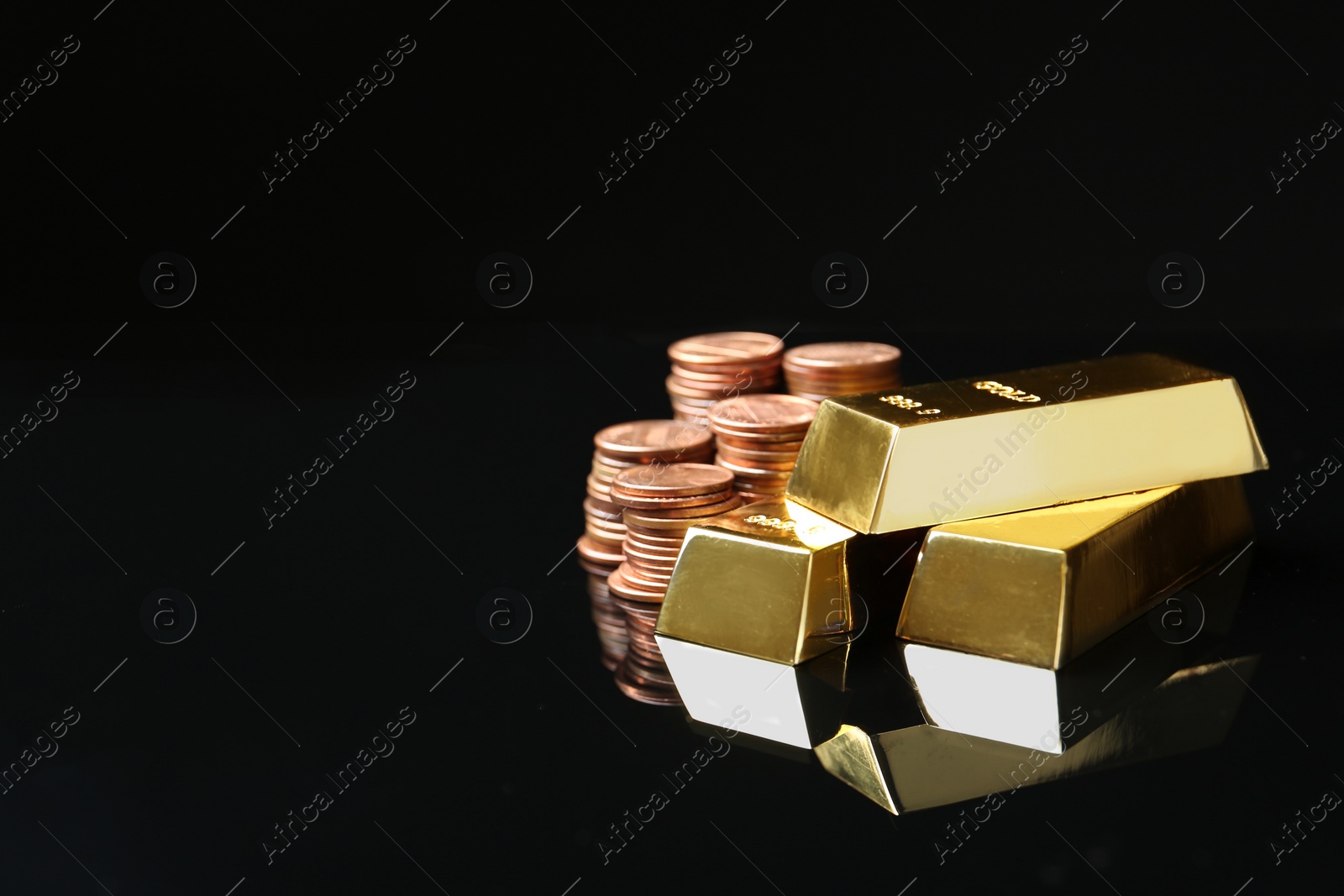 Photo of Shiny gold bars and coins on black background. Space for text