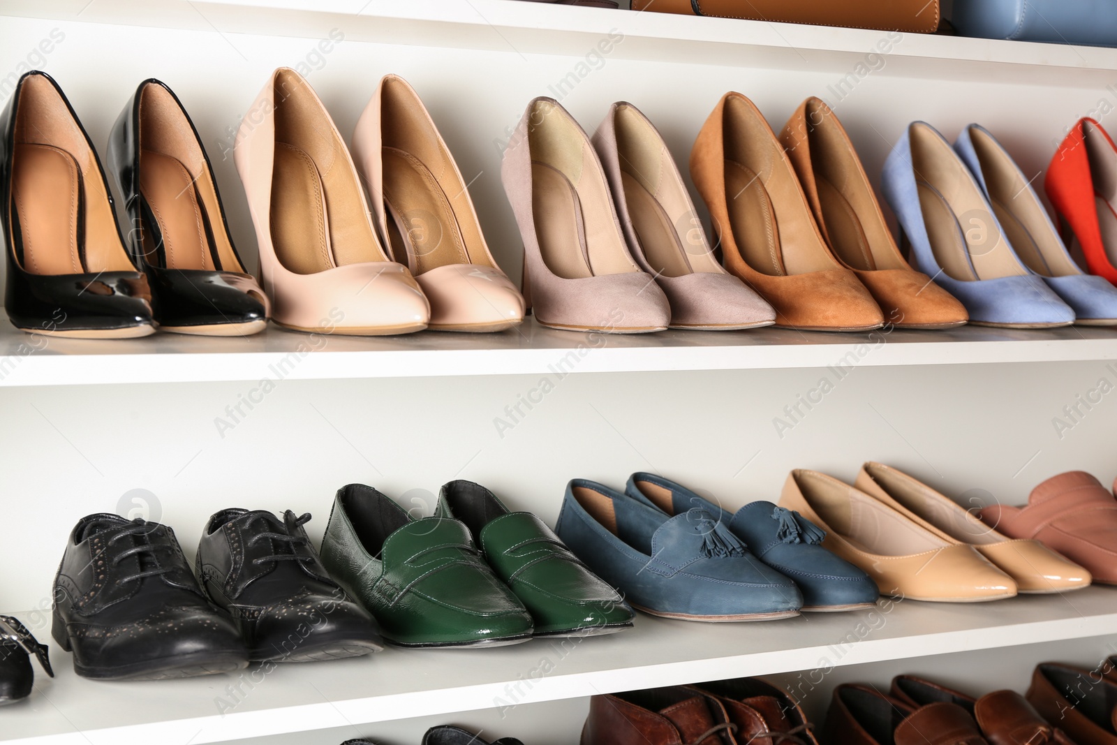 Photo of White shelving unit with different leather shoes