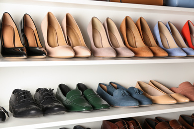 Photo of White shelving unit with different leather shoes