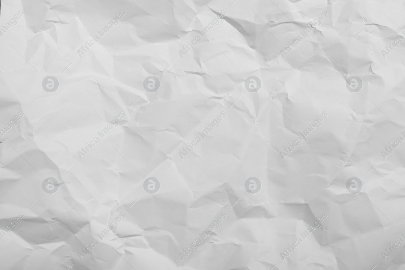 Photo of Sheet of white crumpled paper as background, closeup