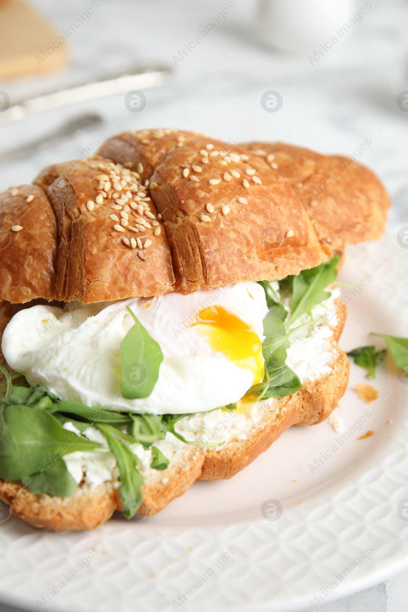 Photo of Delicious croissant with arugula and egg on plate, closeup