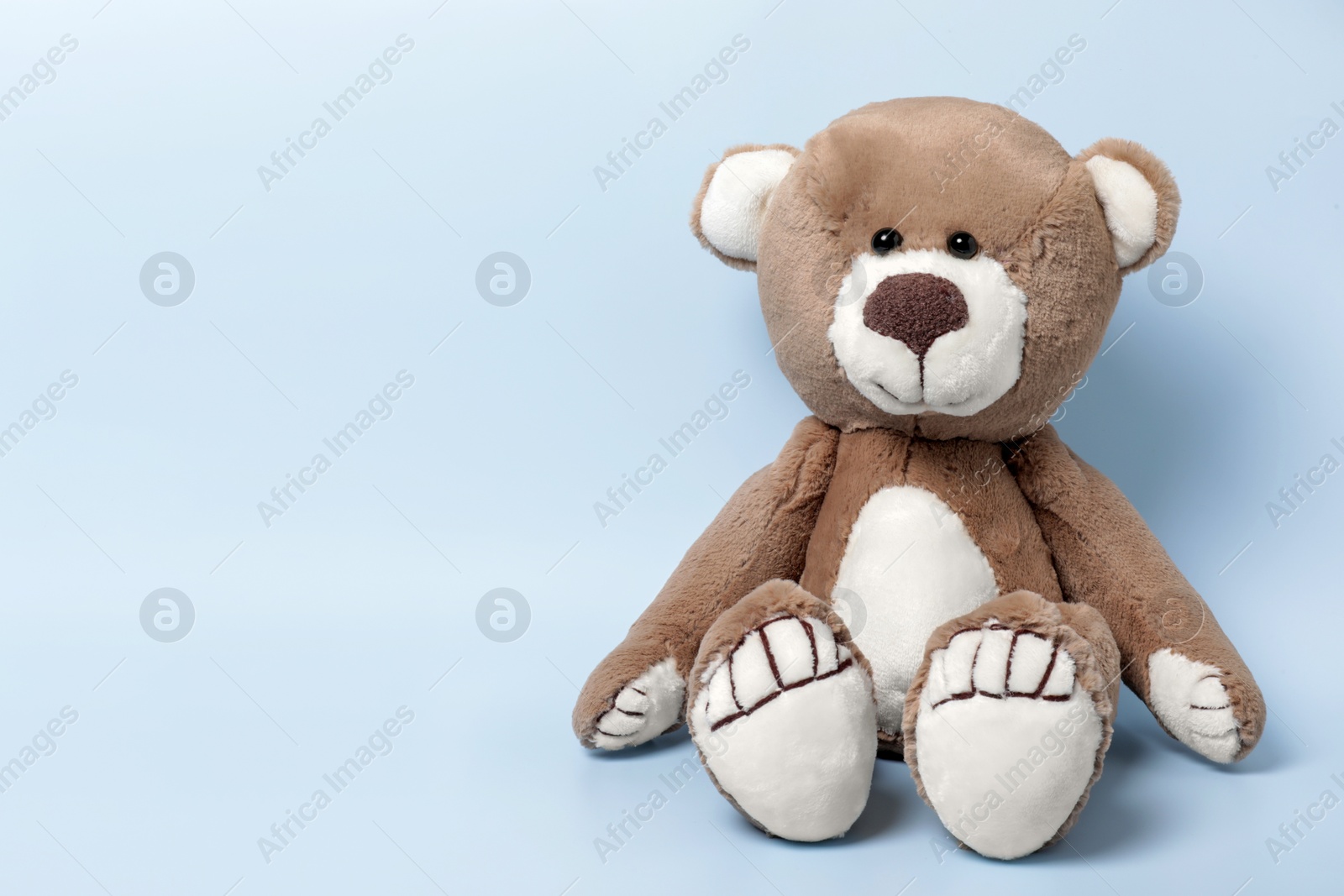 Photo of Cute teddy bear on light background, space for text