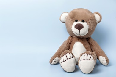 Cute teddy bear on light background, space for text