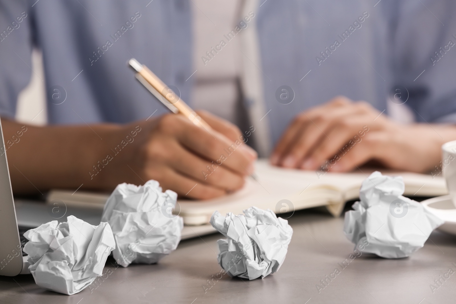 Photo of Woman working at table with crumpled paper, closeup. Generating idea