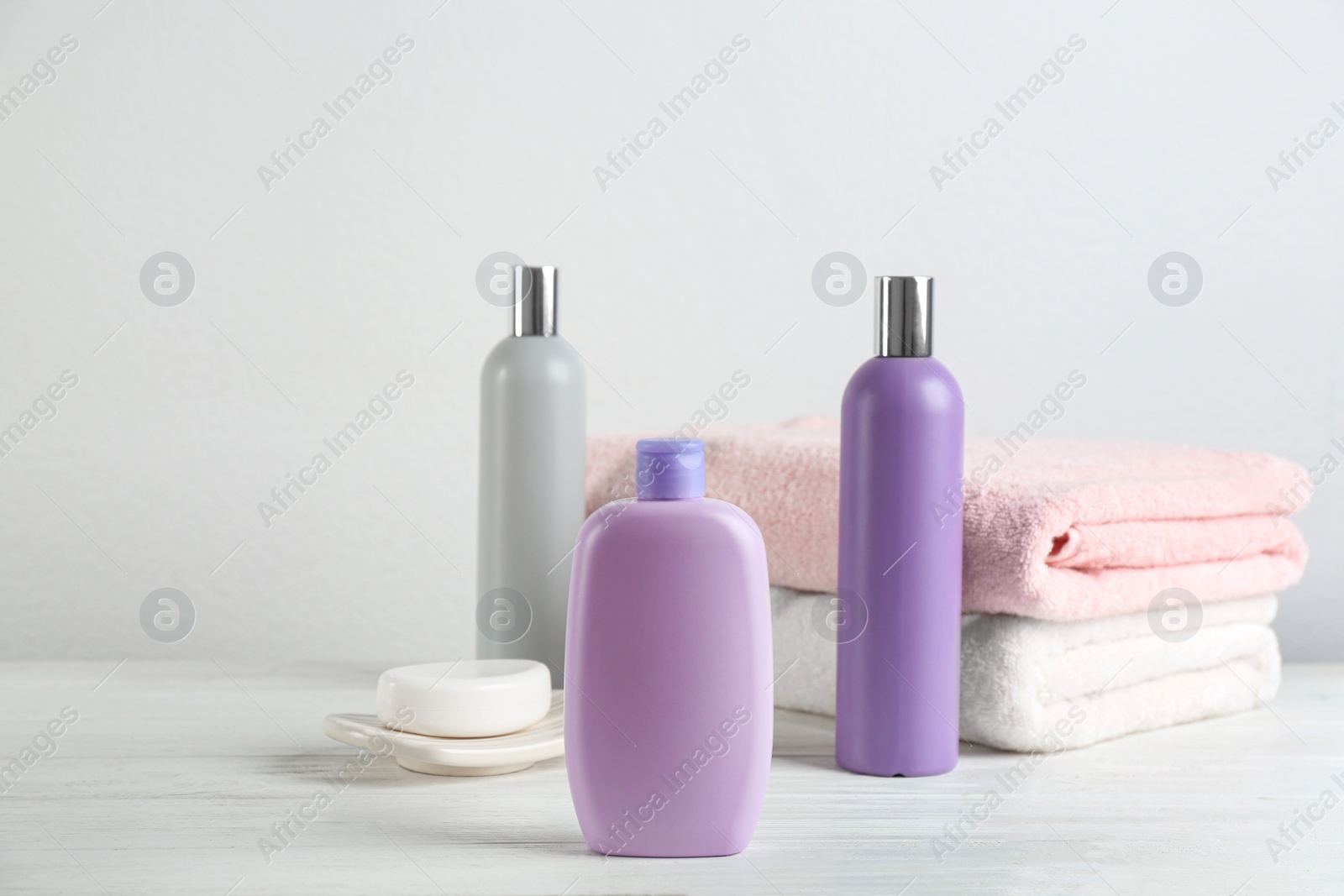 Photo of Fresh towels and toiletries on white wooden table