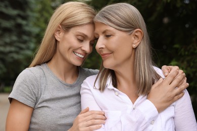 Happy mature mother and her daughter outdoors