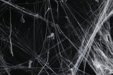 Photo of Creepy white spider web on black background