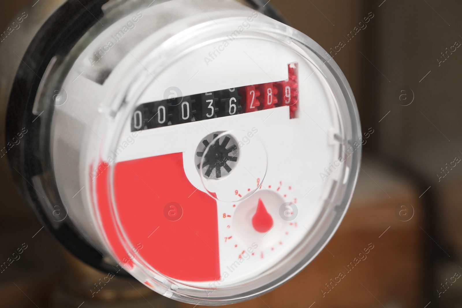 Photo of Closeup view of electric meter on blurred background, space for text. Water measuring device