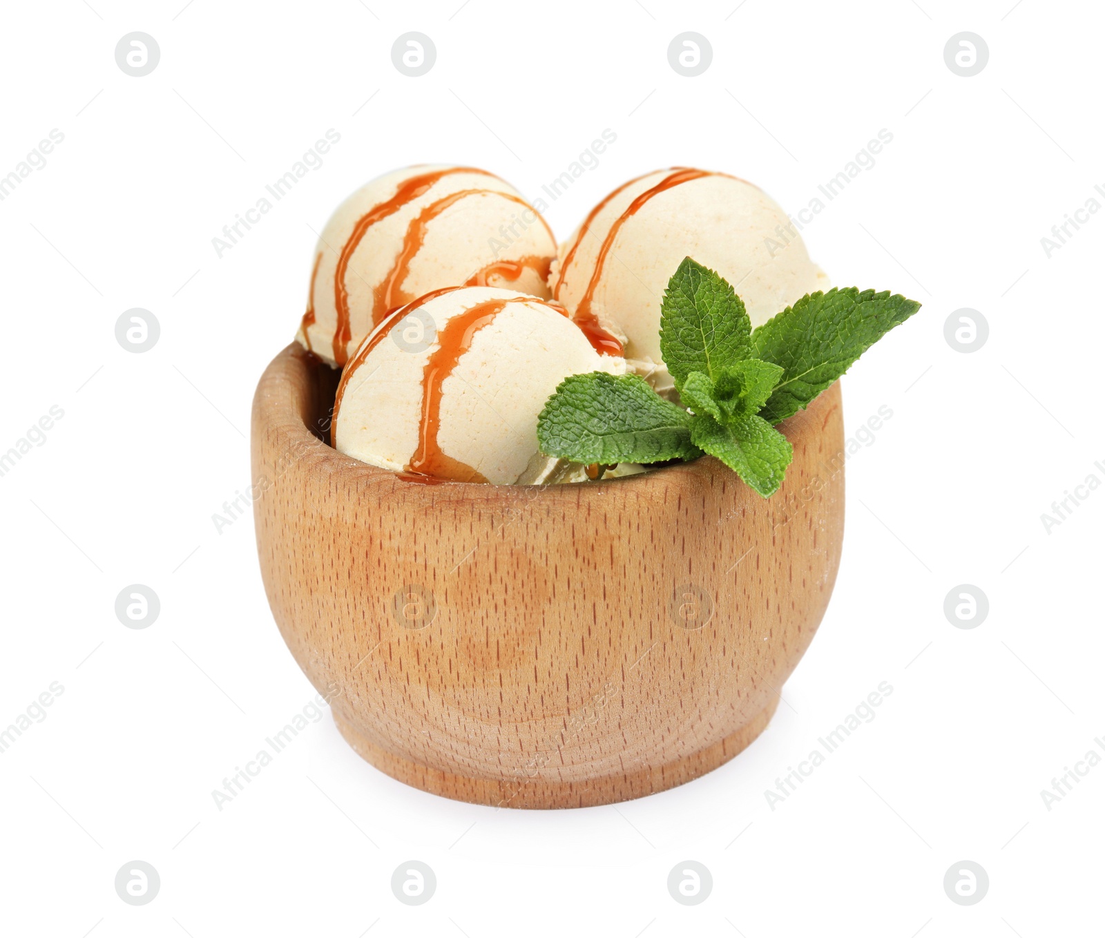 Photo of Delicious ice cream with caramel sauce and mint in wooden bowl on white background