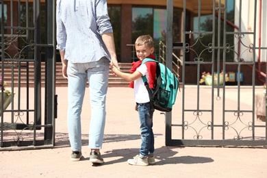 Young father taking his little child to school outdoors