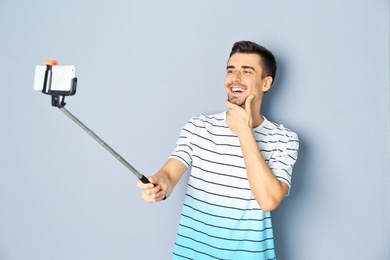 Photo of Young handsome man taking selfie against grey background