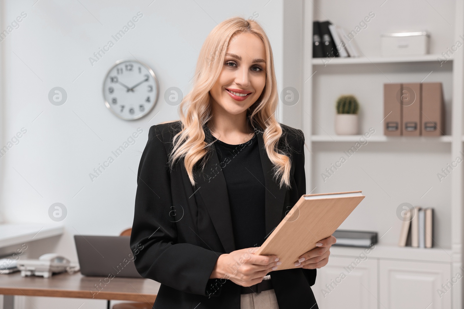 Photo of Portrait of happy secretary with notebook in office