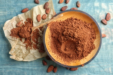 Photo of Flat lay composition with cocoa powder and beans on wooden background