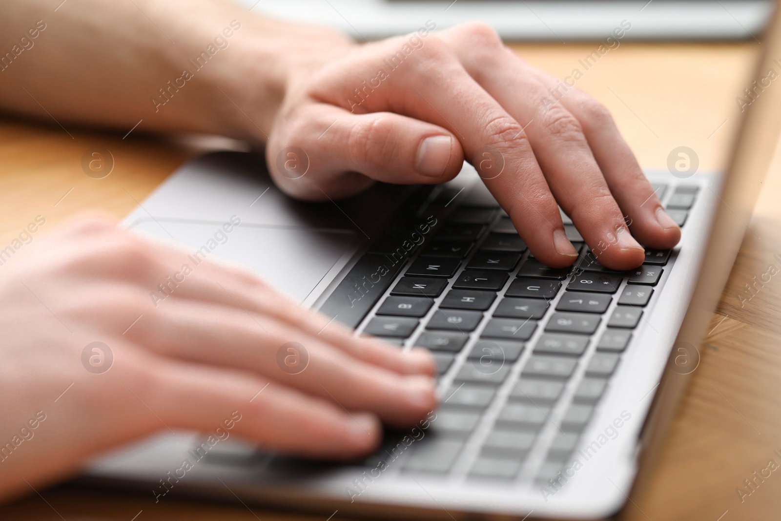 Photo of E-learning. Man using laptop during online lesson at table indoors, closeup