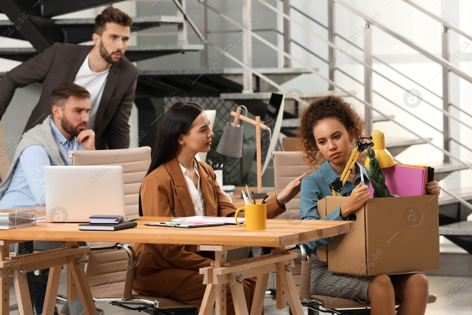 Photo of Young dismissed woman with stuff into box at office