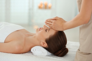 Photo of Beautiful young woman enjoying massage in spa salon