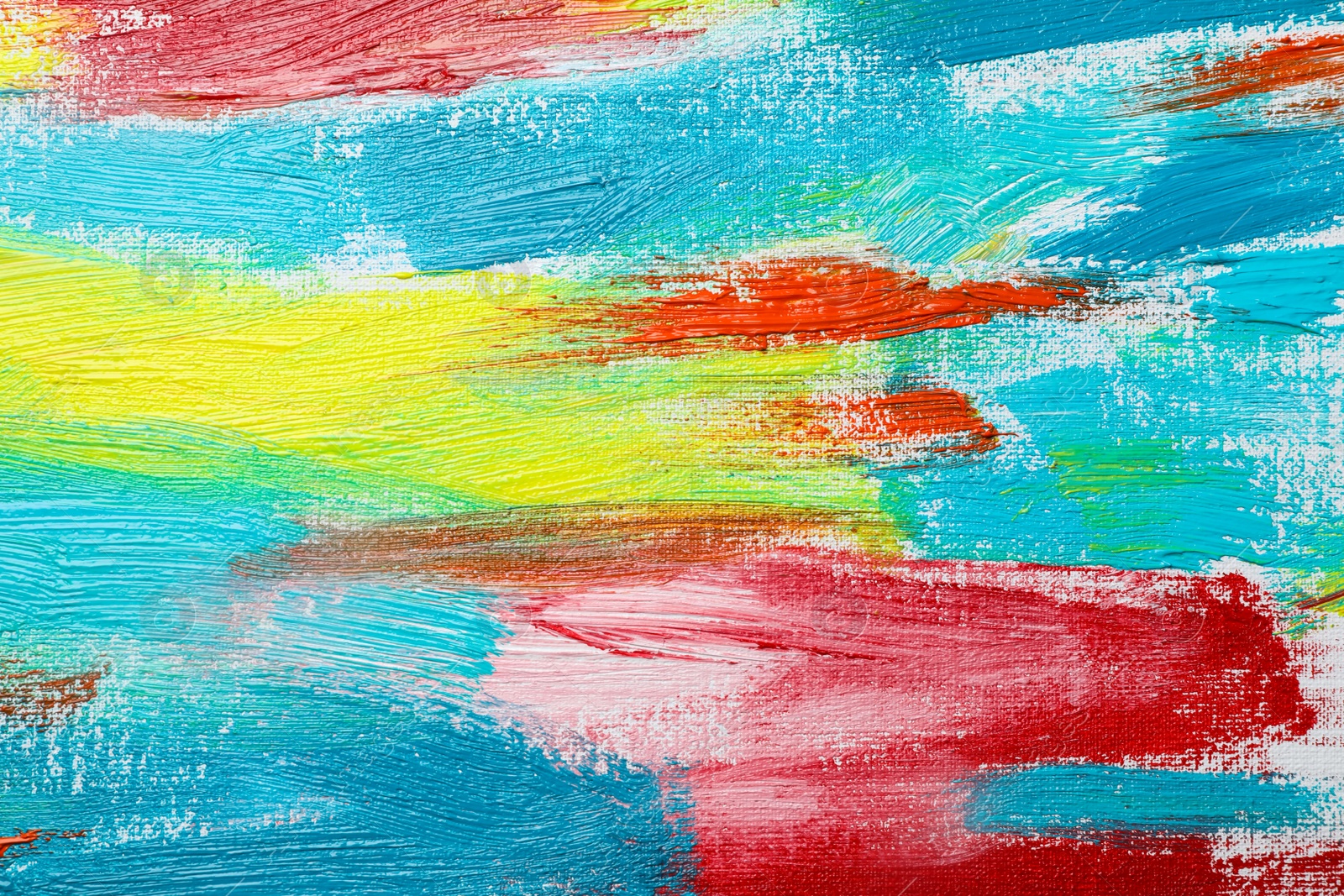 Photo of Strokes of colorful acrylic paints on canvas, closeup