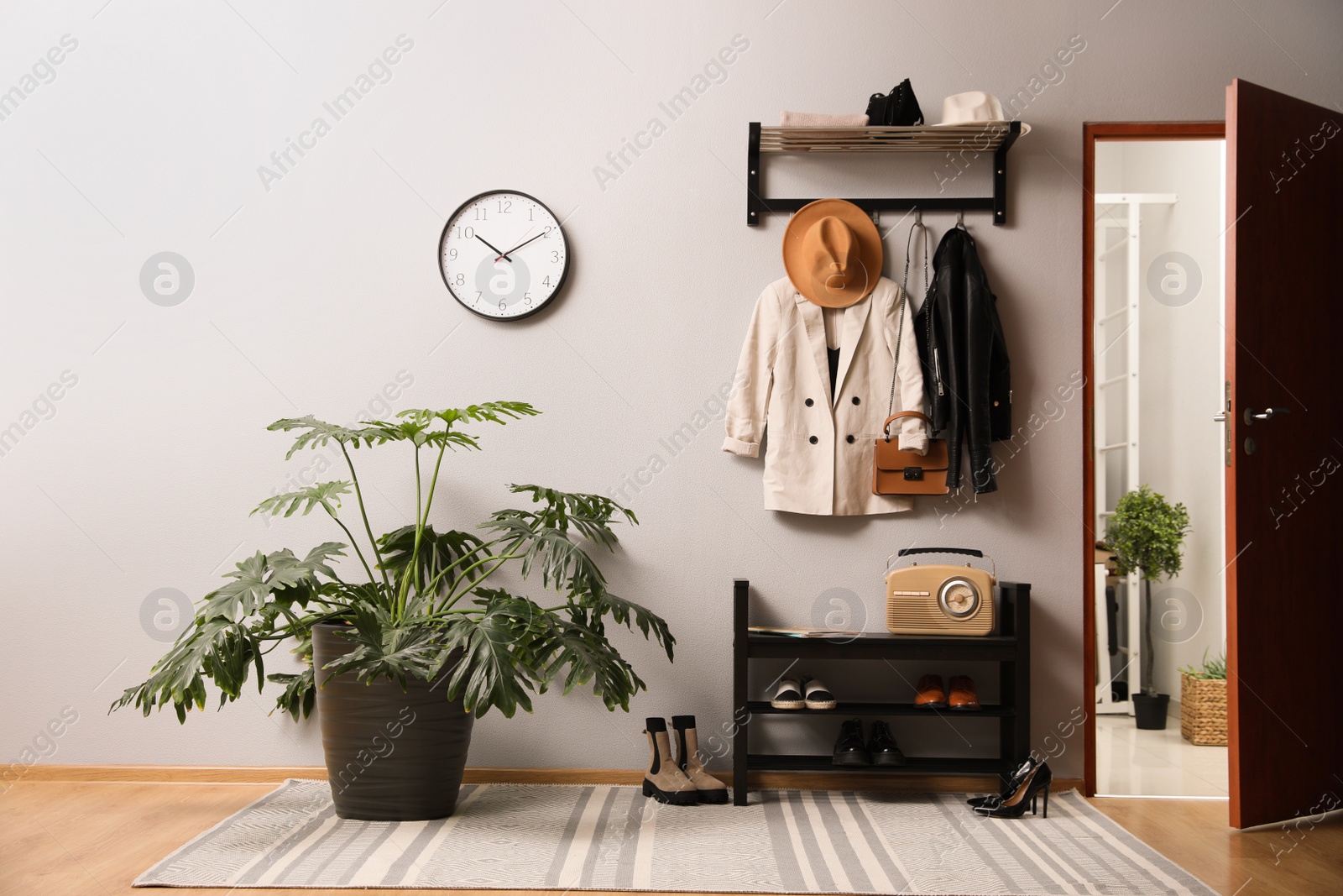 Photo of Hallway interior with stylish furniture, clothes and accessories