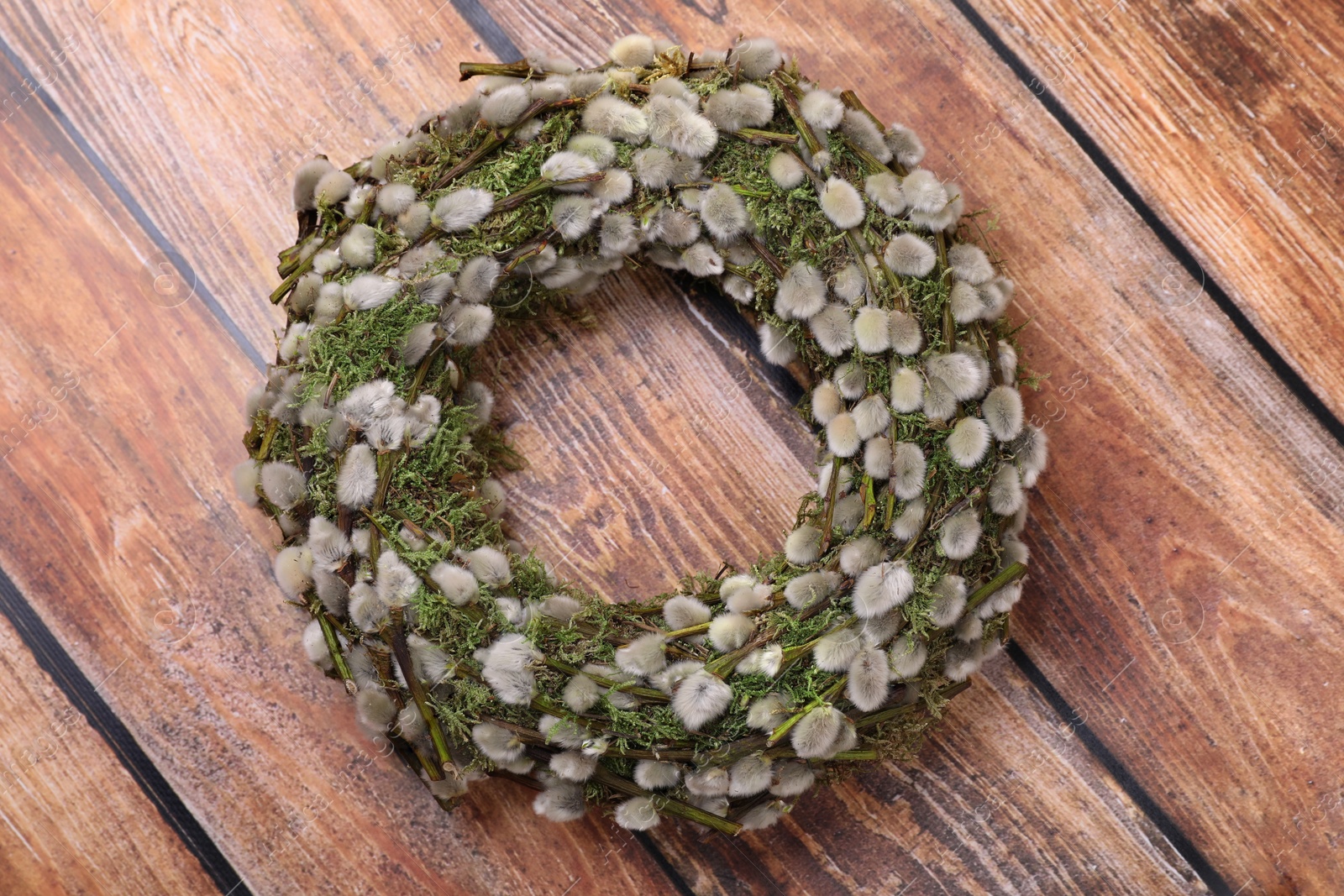 Photo of Wreath made of beautiful willow flowers on wooden table, top view