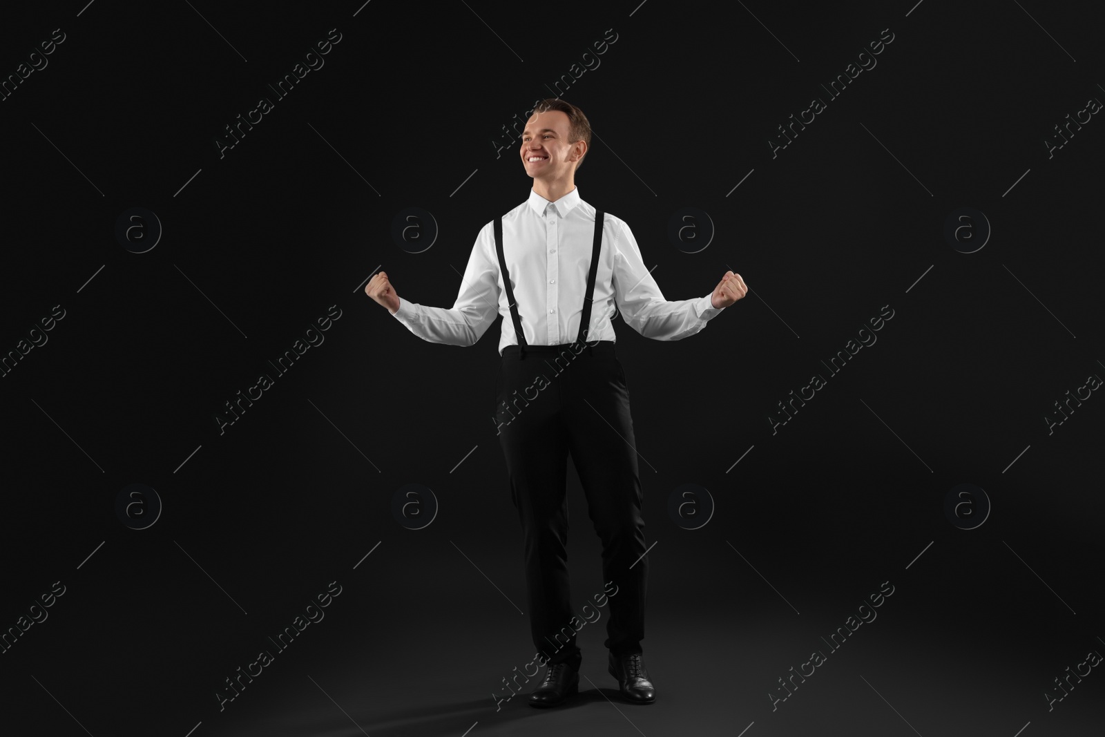 Photo of Cheerful man in white shirt on black background