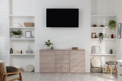 Photo of Stylish TV set mounted on wall in room