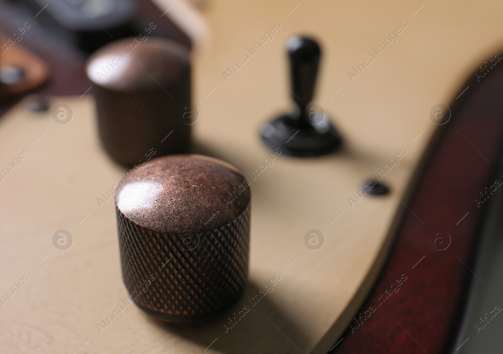 Photo of Closeup view of electric guitar, focus on volume controls