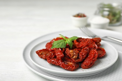 Plate with sun dried tomatoes on light table