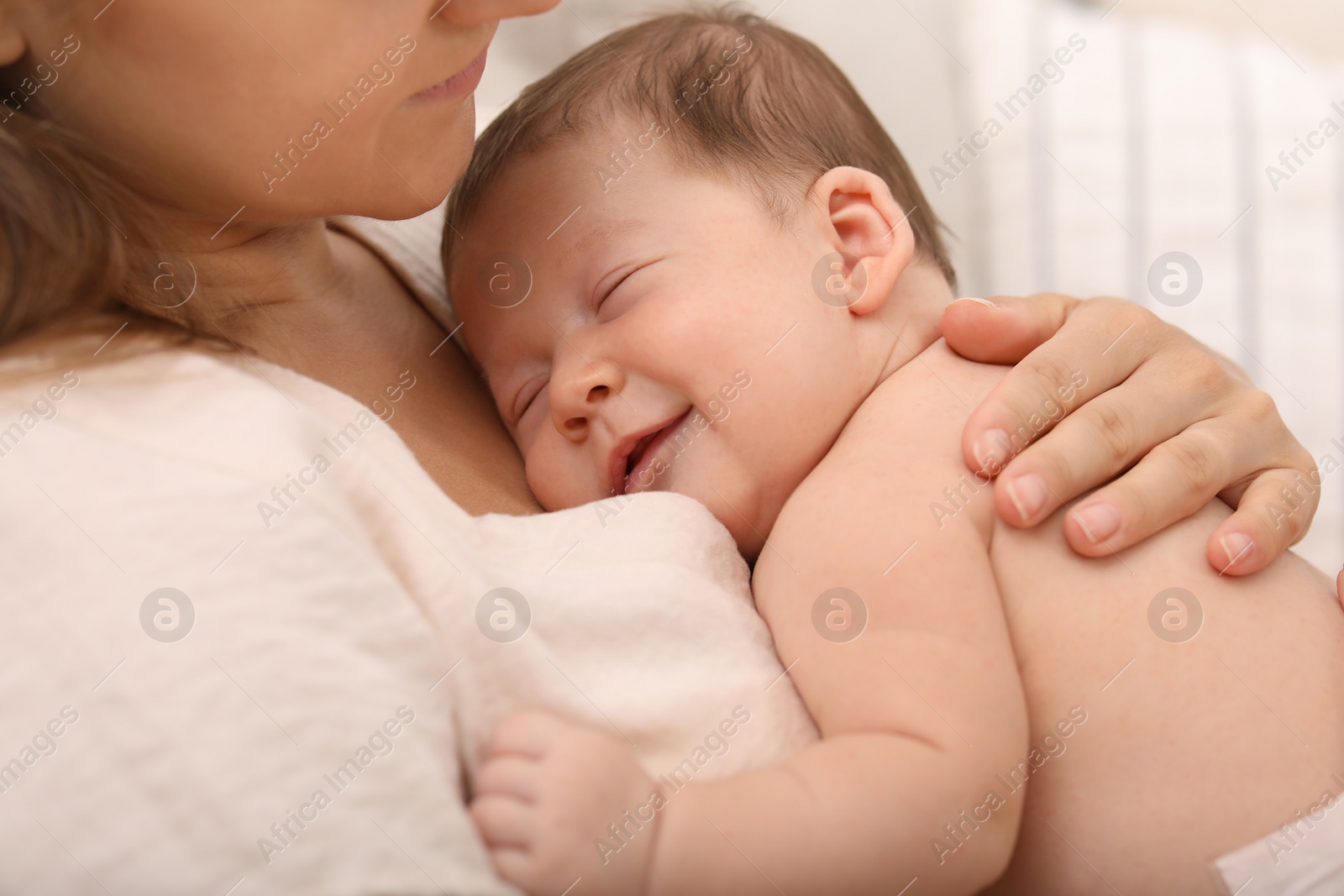 Photo of Mother holding her cute newborn baby indoors