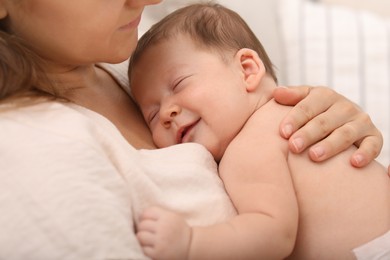 Photo of Mother holding her cute newborn baby indoors