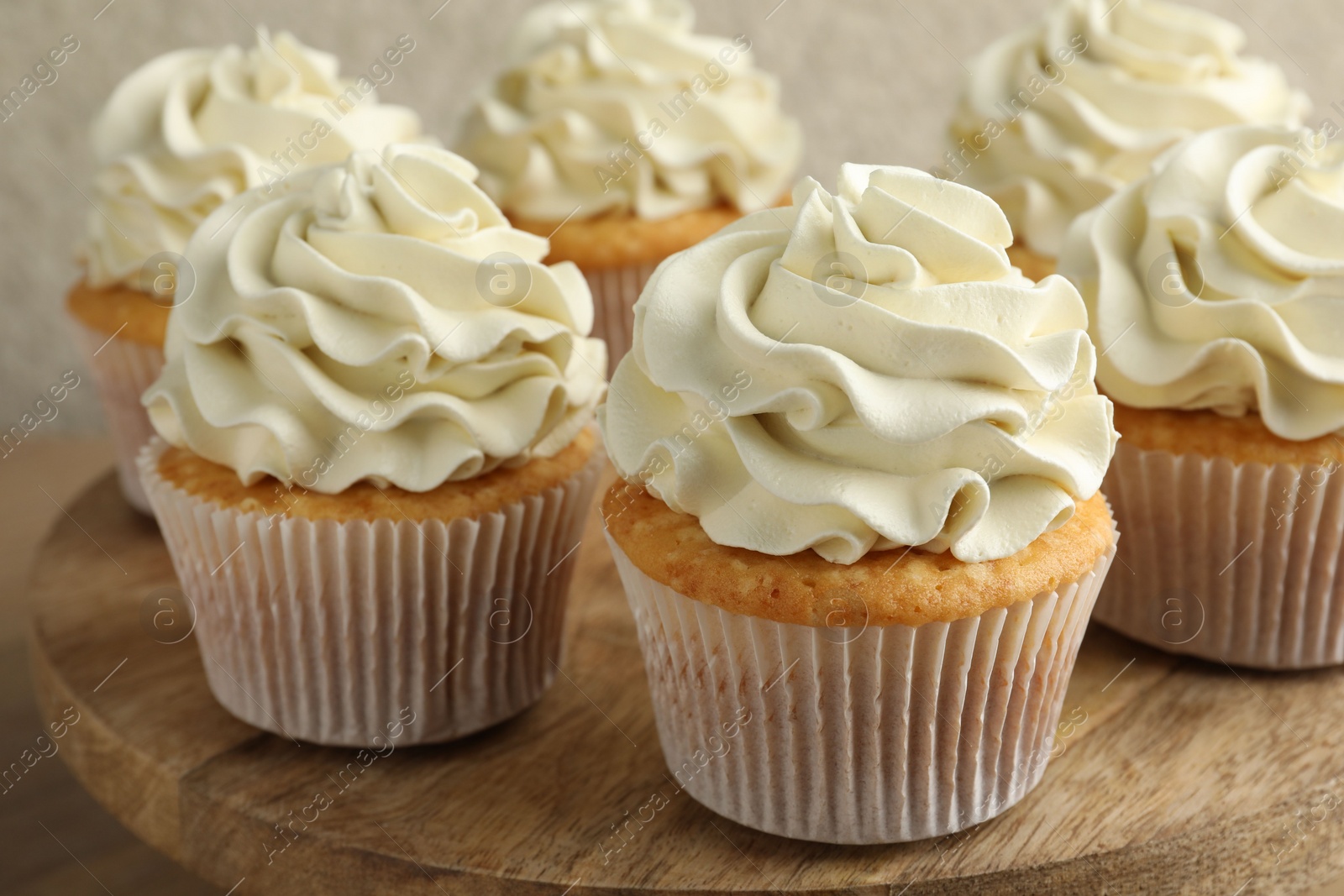 Photo of Tasty vanilla cupcakes with cream on table, closeup