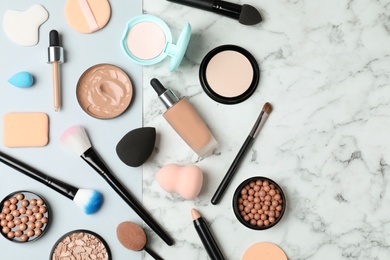 Photo of Flat lay composition with skin foundation, powder and beauty accessories on marble background