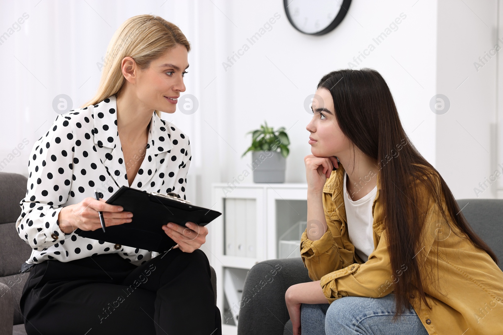 Photo of Psychologist working with teenage girl in office