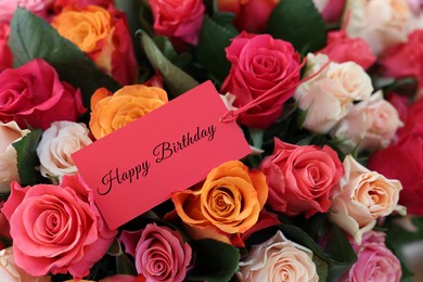 Image of Bouquet of beautiful roses with Happy Birthday card, closeup