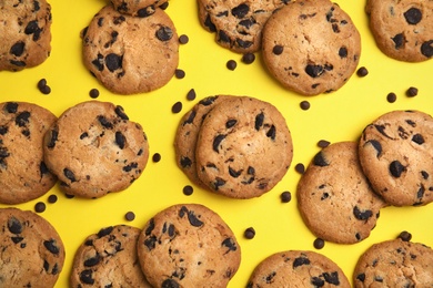 Photo of Delicious chocolate chip cookies on color background, flat lay