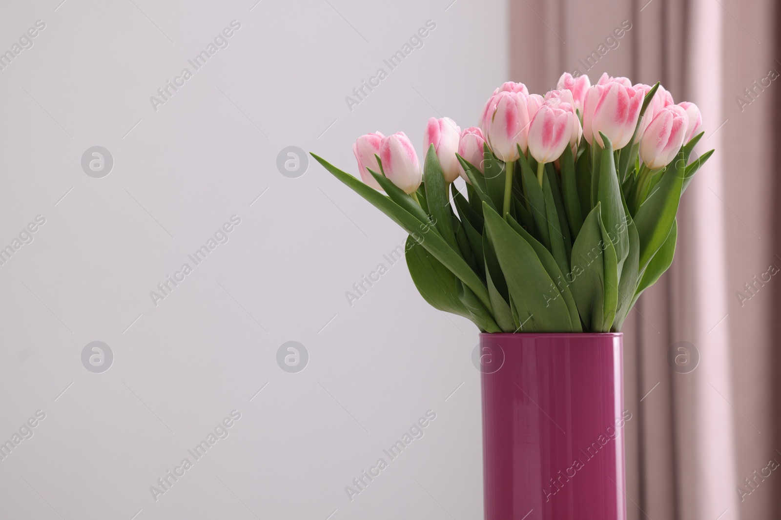 Photo of Beautiful bouquet of fresh pink tulips indoors. Space for text