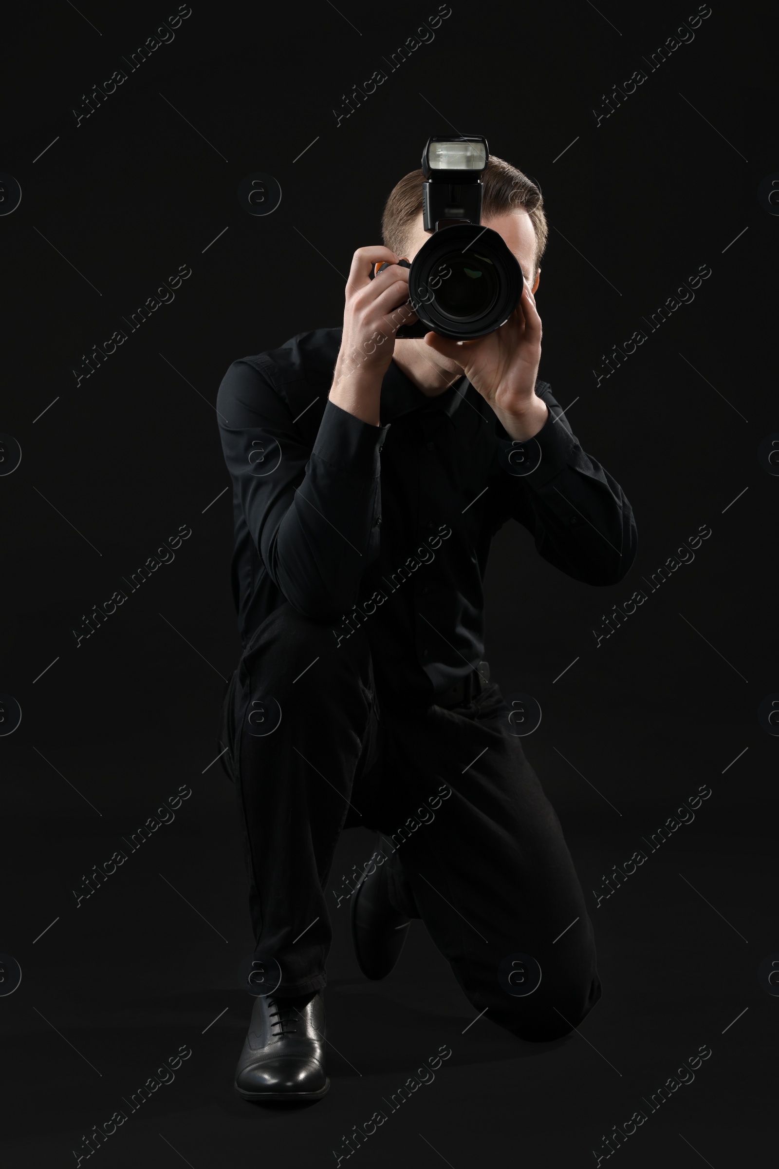 Photo of Professional photographer taking picture on black background