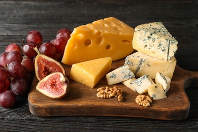 Different delicious cheeses served on wooden board