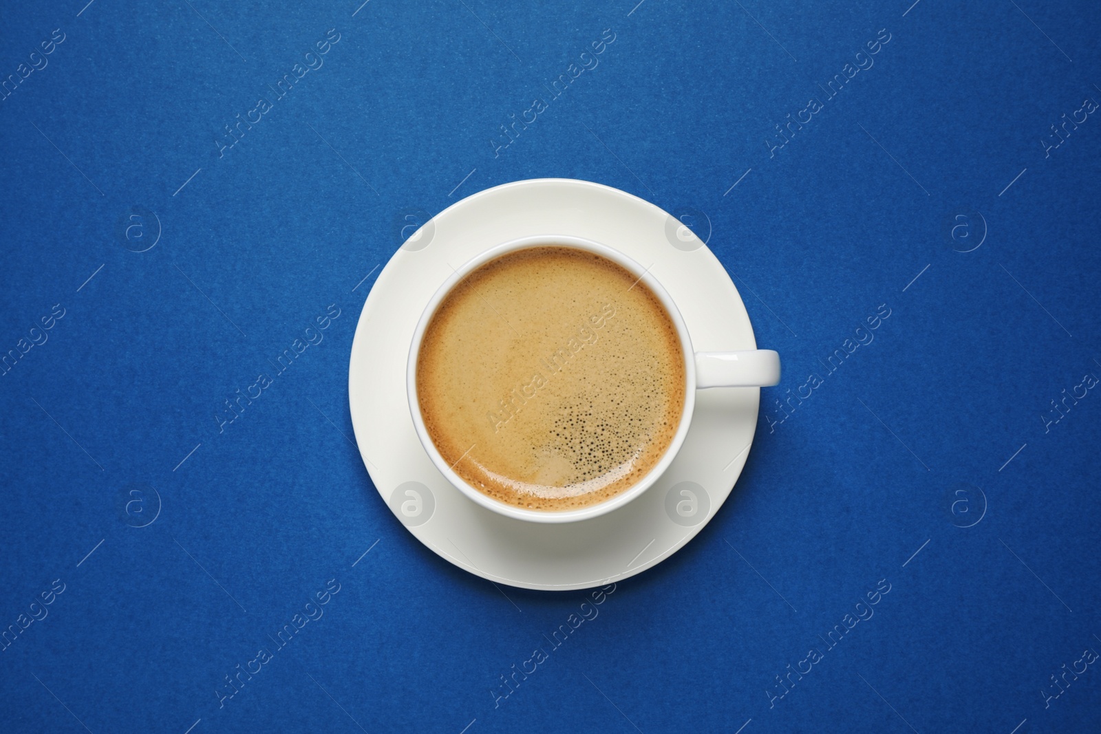 Photo of Classic black coffee on blue background, top view. Color of the year 2020