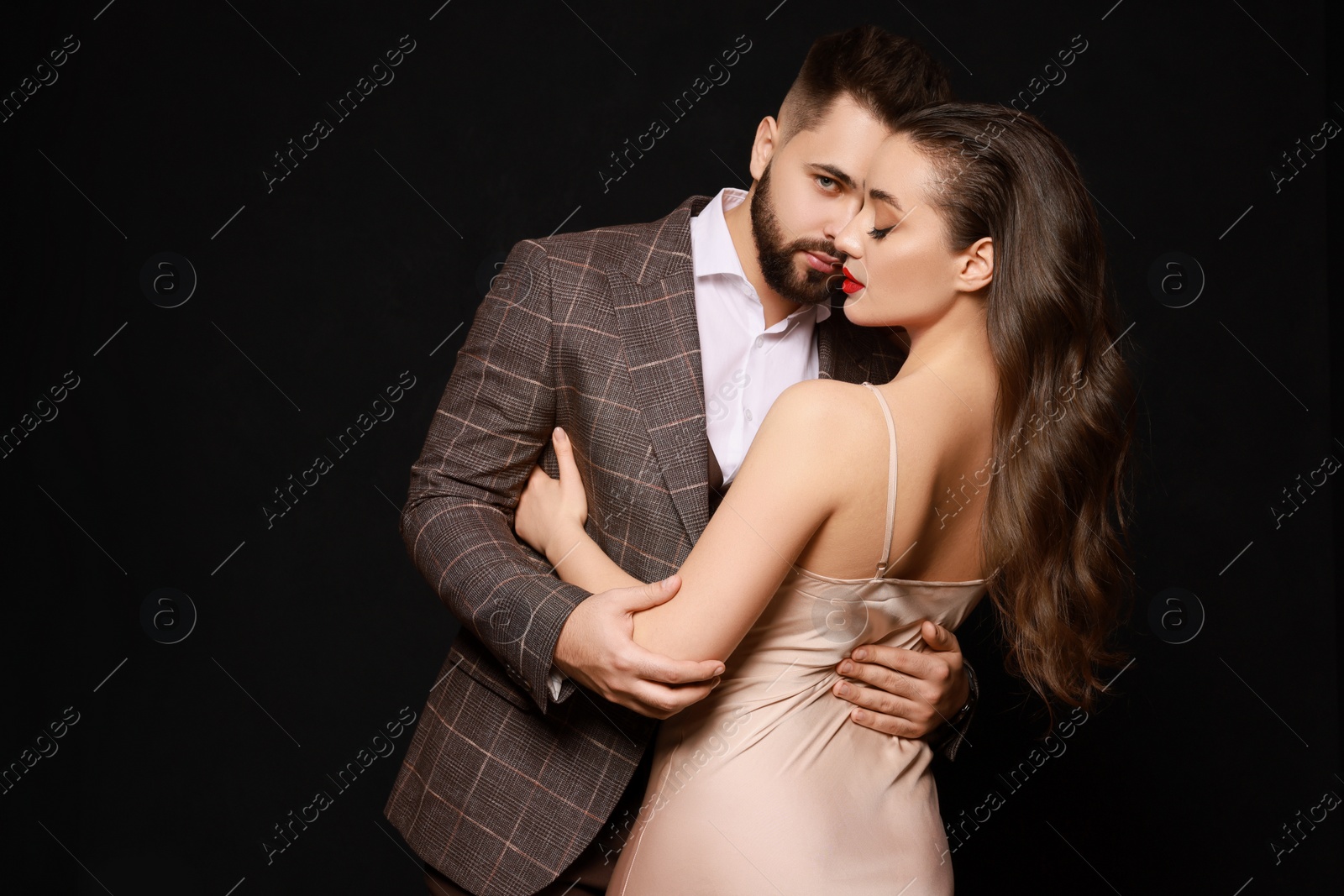 Photo of Handsome bearded man with sexy lady on black background