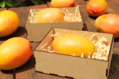 Photo of Delicious ripe juicy mangos on wooden table, closeup