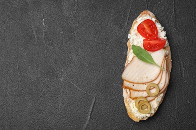 Photo of Delicious chicken bruschetta on dark table, top view. Space for text